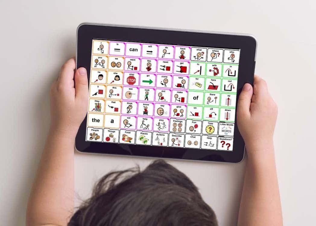Niño sostiene una tableta con un tablero de pictogramas de comunicación