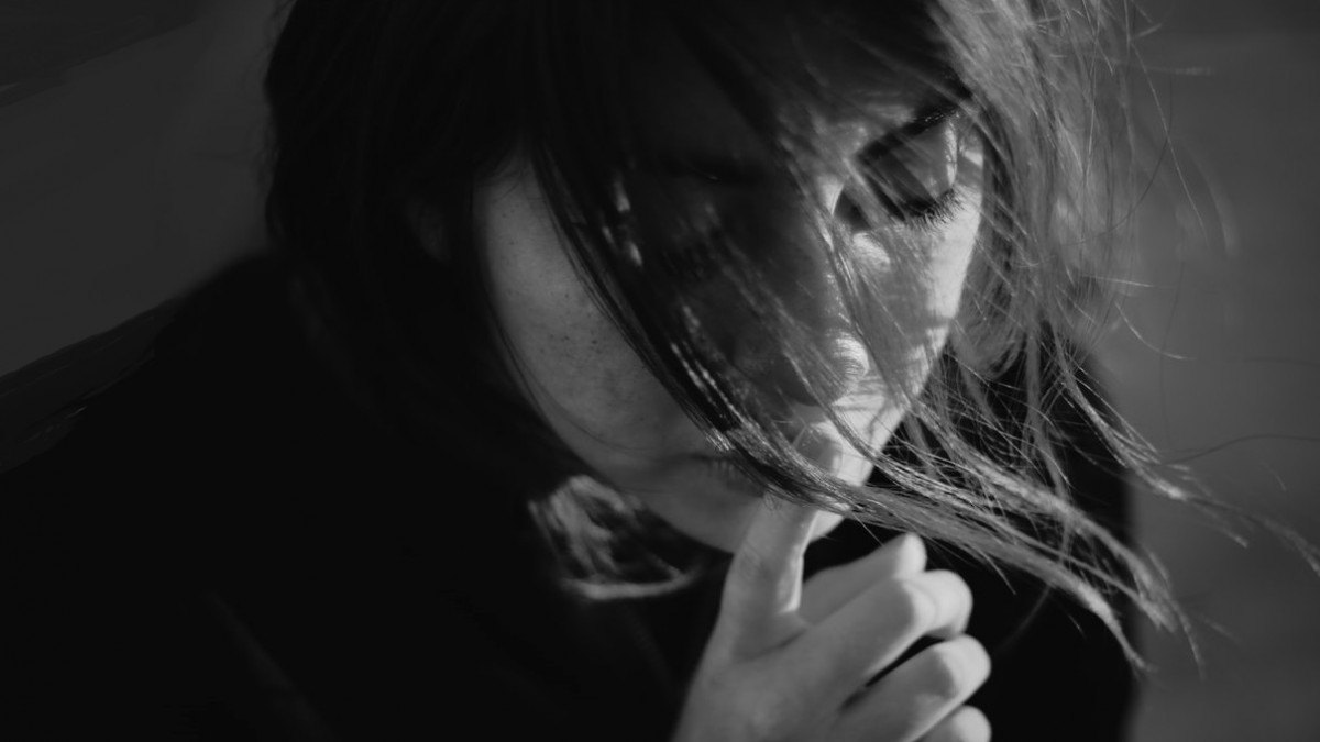 Retrato en blanco y negro de una mujer pensativa con la mirada baja