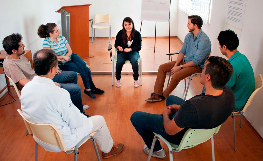 Grupo de personas sentadas en círculo durante una sesión grupal